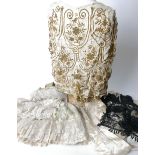 An early 20th Century cream cape embellished with gold coloured beadwork; a black net and bead