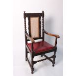 A Victorian carved oak armchair with caned back and leather seat
