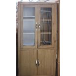 A light oak, glazed-top cupboard (h: 180cm w: 90cm d: 35) with brushed chrome handles.