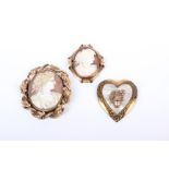 A pair of shell cameo brooches in unmarked yellow metal, together with a yellow metal heart shaped