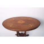 A Victorian mahogany and inlaid oval occasional table on four turned legs.