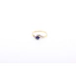 An 18k gold sapphire and diamond single stone crossover ring. central round cut sapphire with two