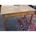 A light oak desk with two short drawers and a small pine dinning table.