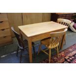 An oak kitchen table with three chairs