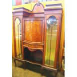 An Edwardian mahogany and inlaid display cabinet the serpentine fronted central cupboard flanked