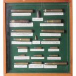 Ammunition. a framed and glazed display case containing 19 decommissioned rounds of ammunition.