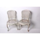 A pair of 19th Century painted and caned chairs