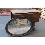 A gate leg drop leaf table, an oval lacquered mirror and an overmantel mirror.