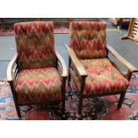 Two reclining upholstered oak armchairs in the arts and crafts style.