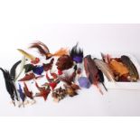 A collection of early 20th Century colourful millinery feathers, some in the form of birds, many