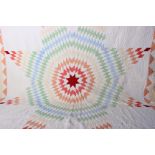 An early 20th Century American quilt, worked in pale shades of yellow, blue, green, orange and