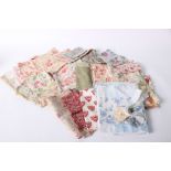 A collection of textiles and scraps suitable for patchwork and similar projects, including floral