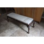 A 17th Century style long footstool with carved trailing frieze on cabriole legs 156cm length