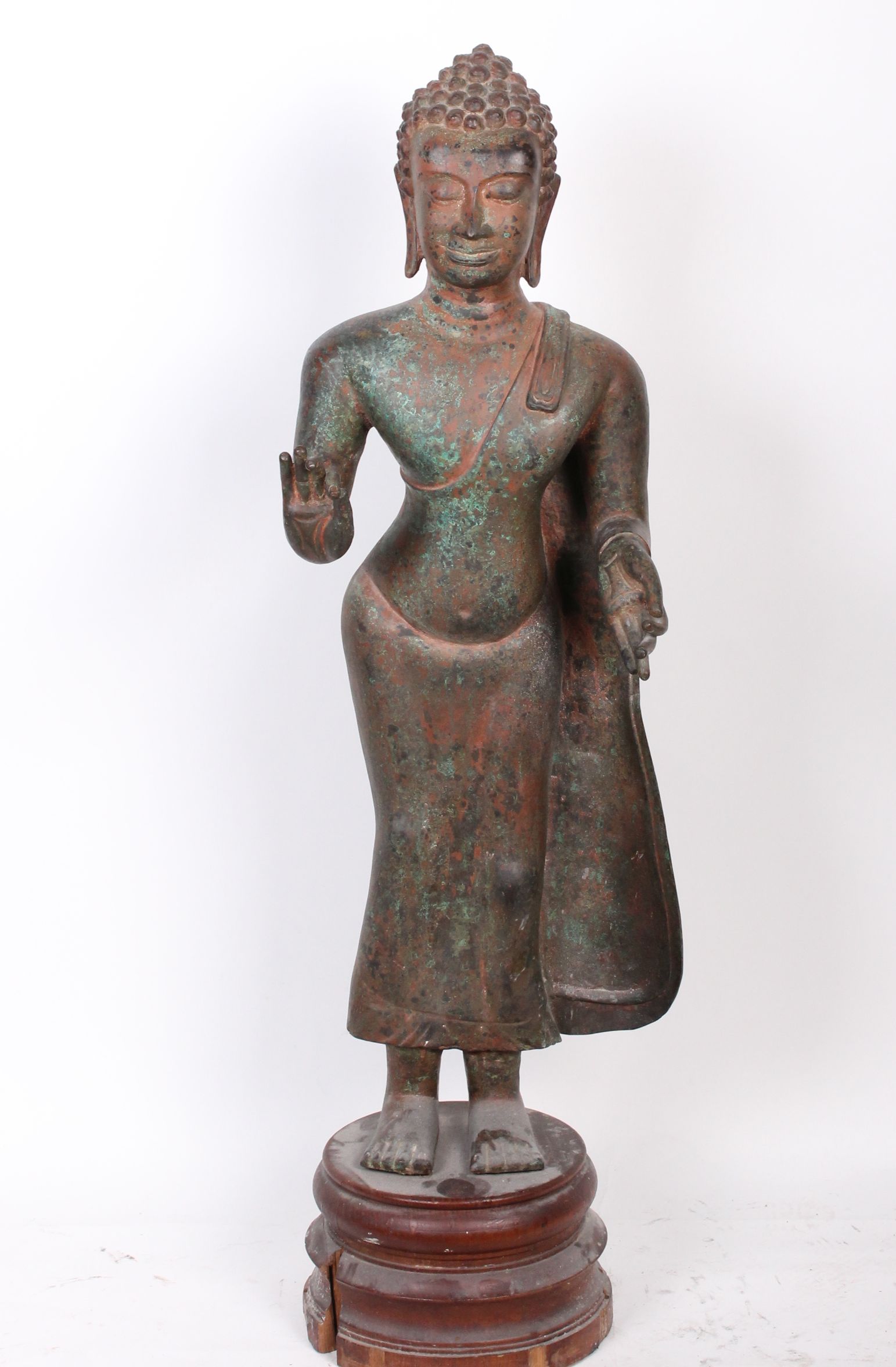 A standing bronze figure of Buddha, Vitarka mudra gesture, on wooden base 122cm high