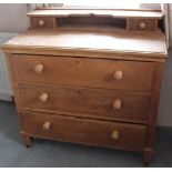 An oak dressing chest of three long drawers with a shaped superstructure 94cm wide