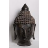 Two bronze heads of meditating Buddhas with elongated earlobes and tightly curled hair 80cm high