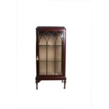 A mahogany display cabinet with arched astragal glazed door, bearing Waring & Gillows label to