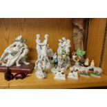 A pair of goldfinch figurines with bocage background, a parianware female riding a tiger on a marble