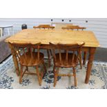 A modern pine dining table and set of four chairs