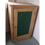 A pine cupboard with green painted door enclosing shelves 102cm high, 68cm wide