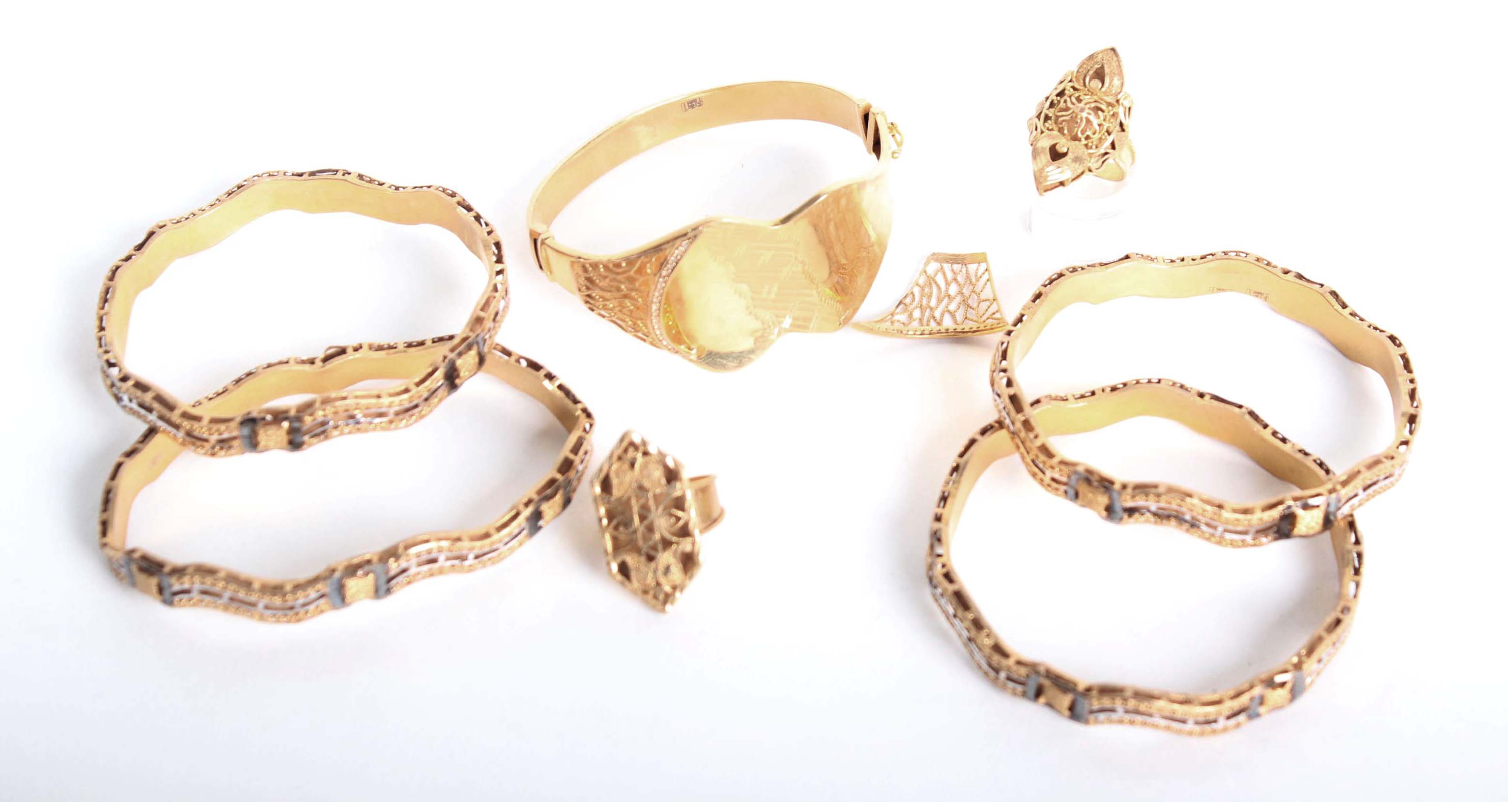 A collection of yellow metal heavy gold plated jewellery to include 5 bangles and two rings.