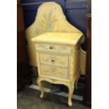 A polychrome painted bedside cupboard with matching single headboard and a Lloyd Loom armchair