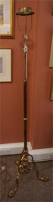 A Victorian brass extending converted oil lamp with reeded column scrolled base with paw feet