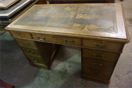 An Edwardian oak kneehole desk