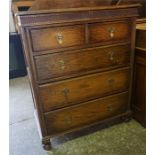 An Edwardian Oak 5 drawer chest with brass pulls, carved decoration, standing on