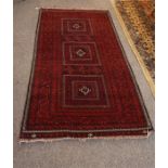 A red, black and ivory Persian rug 78 inches by 40 inches