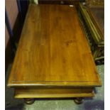 A large mahogany stained teak wood coffee table, oblong shaped with turned legs