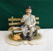 A large Capo-Di-Monte figure of a tramp sitting on a bench