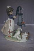 A Lladro porcelain figure group of a girl and birds at water pump