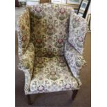 A Georgian style wing Armchair, on square legs and brass roll casters