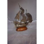 A Portuguese silver model of a Galleon, 21 cm high, raised on a wooden oval base