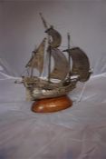 A Portuguese silver model of a Galleon, 21 cm high, raised on a wooden oval base