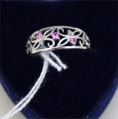 A Ladies 9ct White Gold Dress Ring, with pierced decoration and gem set, probably rubies, with small