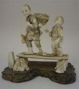 A Japanese Ivory Figure Group, Meiji period circa 1900, modelled as a father and son, 19cm high,
