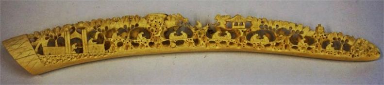 A Carved Ivory Tusk, probably Oriental, decorated with figures and pagodas, 35.5cm long