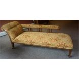 An Edwardian Oak Chaise Longue, upholstered in later gold coloured fabric with floral panels, raised
