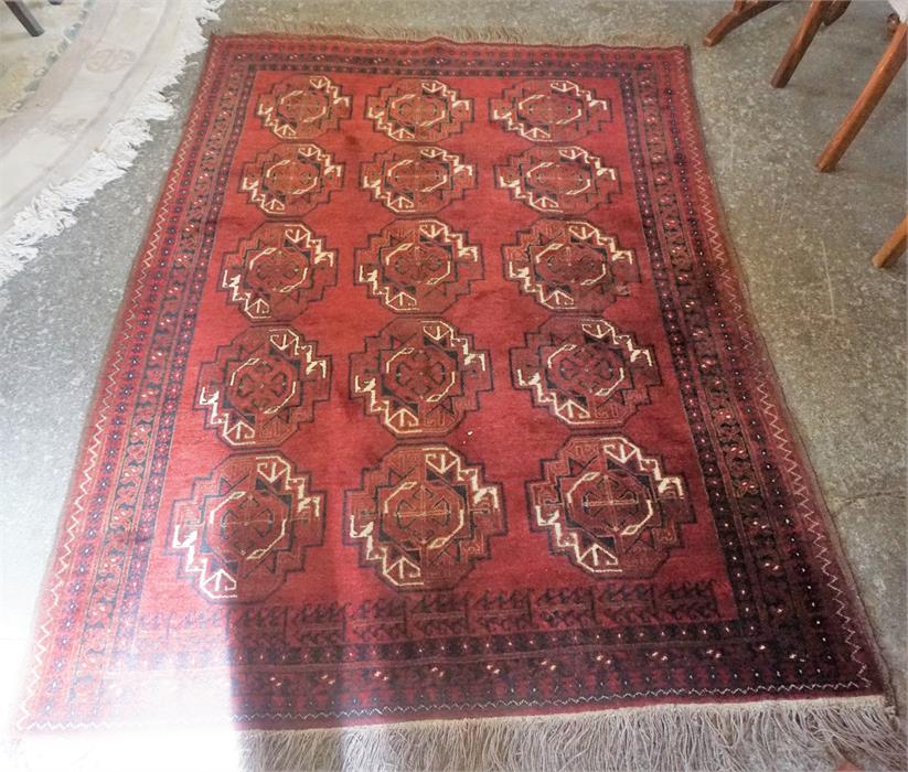 A Hamadan Machine Made Rug, Decorated with five rows of three Geometric medallions on a red