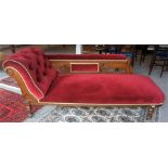 A Late Victorian Oak Framed Chaise Longue, upholstered in later red dralon, raised on turned legs,