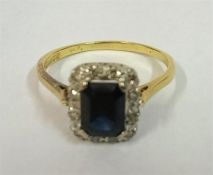 A Ladies 18ct Gold Princess Cut Sapphire Dress Ring, the centre stone surrounded with Diamonds, ring