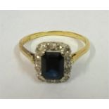 A Ladies 18ct Gold Princess Cut Sapphire Dress Ring, the centre stone surrounded with Diamonds, ring