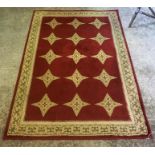 A Kashmir Machine Made Rug, Decorated with rows of star motifs on a red ground, 161 x 110cm