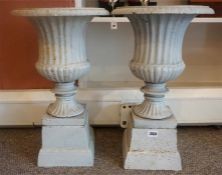 A Pair Of Painted Metal Campagna Urns, raised on square stand, 49cm high, (2)