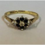 A White Gold Ladies Dress ring, set with Diamonds and Sapphires in a flower shape setting, size L