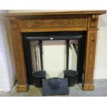 A Carved Wood Fireplace, with painted cast iron insert, to include grate and canopy, (insert 82 x