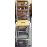 A Set Of Six Stacking Stools, with wooden seat raised on a painted metal frame, 63cm high, 38cm