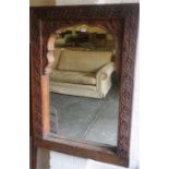 A Large Carved Wood Wall Mirror, the frame is decorated with carved flowerhead roundels, 117cm high,